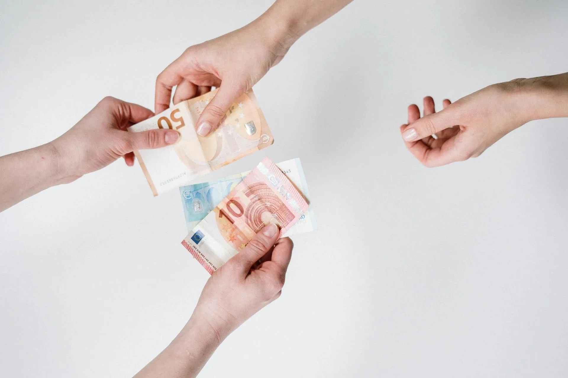 Euro banknotes being handed between people